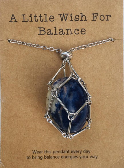 Necklace with a blue stone pendant on a brown card with text; Wearing a quartz stone necklace, particularly clear quartz, offers benefits including amplified energy, enhanced mental clarity, and emotional balance. Often called the "master healer," it is believed to harmonize your aura, aid in manifestation, and improve focus.