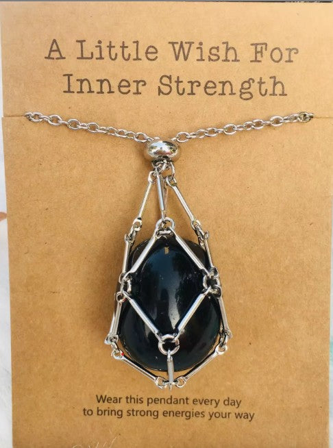 Necklace with a black pendant on a brown card with text; Wearing a quartz stone necklace, particularly clear quartz, offers benefits including amplified energy, enhanced mental clarity, and emotional balance. Often called the "master healer," it is believed to harmonize your aura, aid in manifestation, and improve focus.