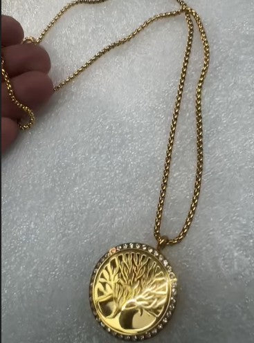 Gold chain with tree of life pendant ; small rhinstones. An aromatherapy necklace allows you to enjoy the benefits of essential oils anywhere—reducing stress, boosting energy, or improving focus throughout the day.. The necklace provides a personal, portable, and stylish way to diffuse oils near your nose, influencing moods via the limbic system. Portable Wellness to enhance Mood and Health Support: Depending on the oil used, you can stay calm, focused, or energized during work, school, or yoga sessions