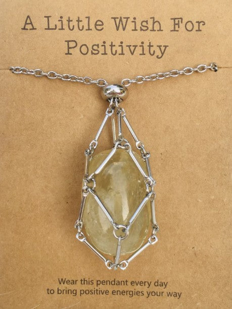 Necklace with a yellow stone pendant on a brown card with text; Wearing a quartz stone necklace, particularly clear quartz, offers benefits including amplified energy, enhanced mental clarity, and emotional balance. Often called the "master healer," it is believed to harmonize your aura, aid in manifestation, and improve focus.