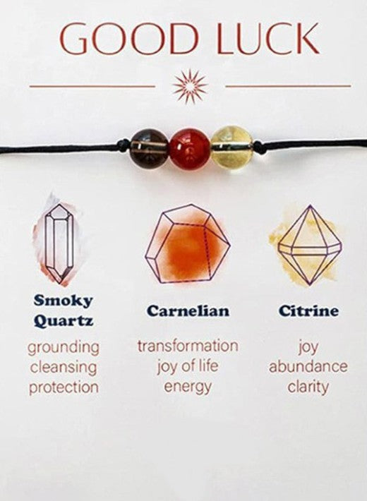 Necklace with stones labeled 'Smoky Quartz', 'Carnelian', and 'Citrine' with their respective energies on a white background. Symbolic Jewelry can represent personal intentions, such as balance, gratitude, or strength, helping you feel more empowered or calm. Wearing meaningful jewelry daily becomes a comforting ritual, providing a sense of stability and familiar ease in your everyday life. Self-Care and Well-being: Gifting yourself or wearing intentional jewelry can enhance your mood, increase feelings of 
