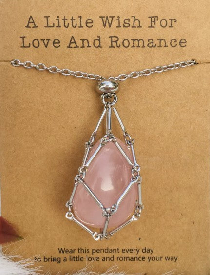 Necklace with pink pendant on a brown card with text; Wearing a quartz stone necklace, particularly clear quartz, offers benefits including amplified energy, enhanced mental clarity, and emotional balance. Often called the "master healer," it is believed to harmonize your aura, aid in manifestation, and improve focus.
