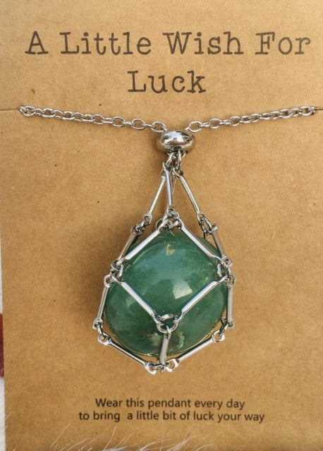 Necklace with green pendant and silver chain on a brown card with text; Wearing a quartz stone necklace, particularly clear quartz, offers benefits including amplified energy, enhanced mental clarity, and emotional balance. Often called the "master healer," it is believed to harmonize your aura, aid in manifestation, and improve focus.